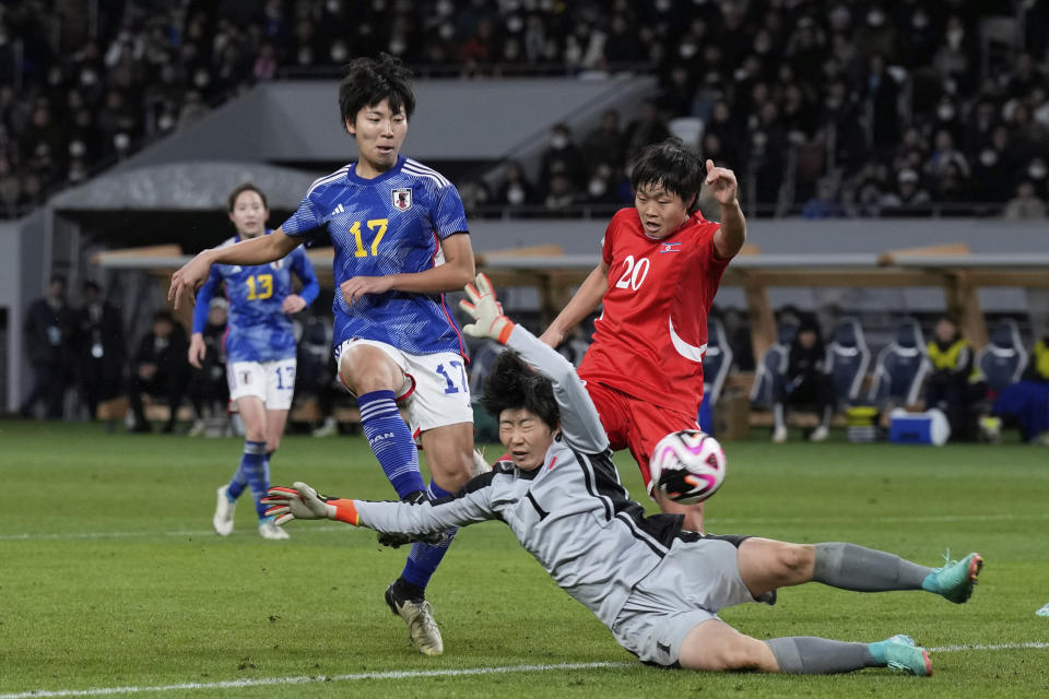 Japan's Kiko Seike, left, kicks the ball in an attempt to score as North Korea's goalkeeper Pak Ju Mi dives in to save the ball during the final qualifier for the Paris Olympic women's football tournament at the National Stadium Wednesday, Feb. 28, 2024, in Tokyo. (AP Photo/Eugene Hoshiko)