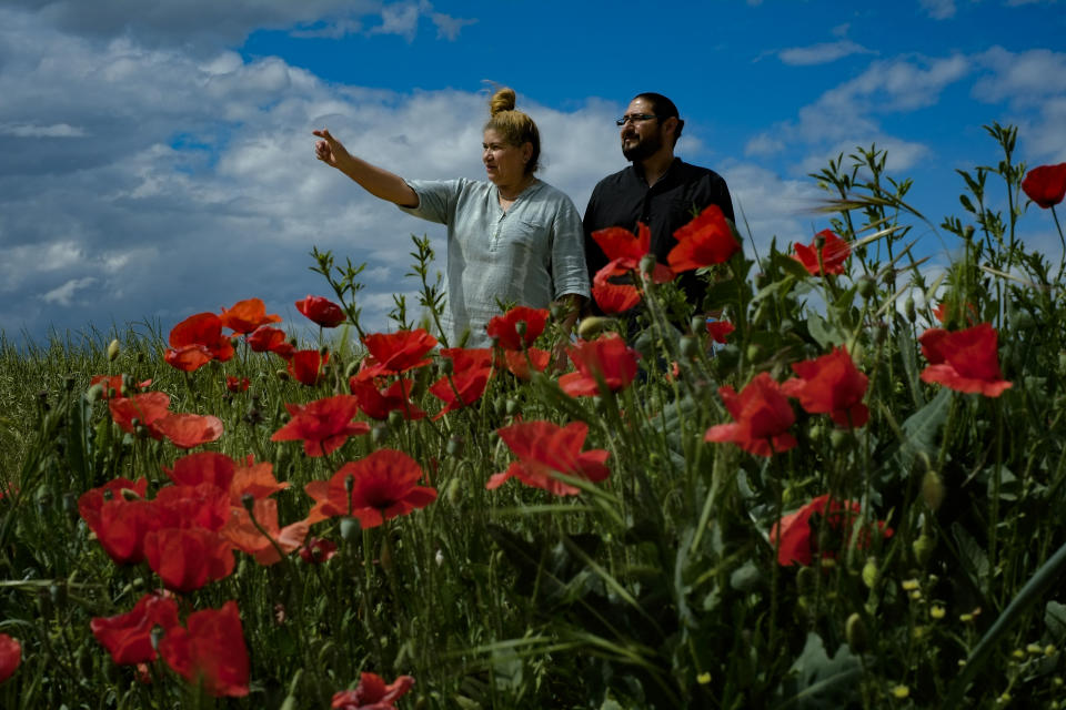 Christian Ramirez, 41, and Lourdes Gonzalez, 54, pose during the "Camino de Santiago" or St. James Way in Redesilla, northern Spain, Tuesday, May 31, 2022. Over centuries, villages with magnificent artwork were built along the Camino de Santiago, a 500-mile pilgrimage route crossing Spain. Today, Camino travelers are saving those towns from disappearing, rescuing the economy and vitality of hamlets that were steadily losing jobs and population. “The Camino is life,” say villagers along the route. (AP Photo/Alvaro Barrientos)