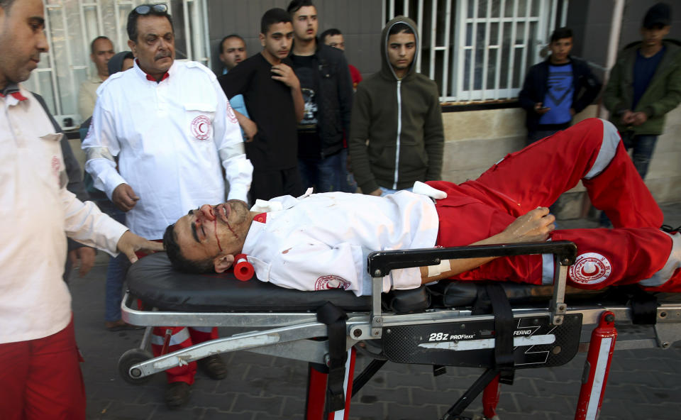 Medics move their wounded colleague, who was shot by Israeli troops during a protest at the Gaza Strip's border with Israel, into the treatment room of Shifa hospital in Gaza City, Friday, May 3, 2019. Three Palestinians, including two militants, were killed by Israeli fire Friday after gunshots from the Gaza Strip wounded two Israeli soldiers, officials said, in a new flare-up that shattered a month-long easing of hostilities that was mediated by Egypt. (AP Photo/Adel Hana)