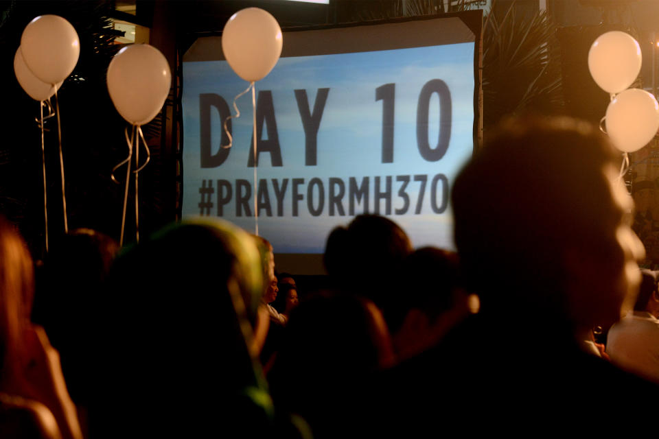 Visitors are silhouetted against a slideshow of best wishes for the missing Malaysia Airline, MH370, during an event at a shopping mall, in Petaling Jaya, on the outskirts of Kuala Lumpur, Malaysia, Tuesday, March 18, 2014. A coalition of 26 countries, including Thailand, are looking for Malaysia Airlines Flight 370, which vanished March 8 with 239 people aboard on a night flight from Kuala Lumpur to Beijing. Search crews are scouring two giant arcs of territory amounting to the size of Australia — half of it in the remote seas of the southern Indian Ocean. (AP Photo/Joshua Paul)