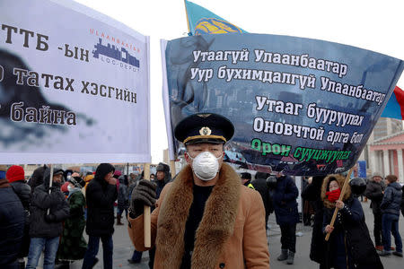 A protester wears a face mask and holds a banner during an anti-pollution protest in central Ulaanbaatar, Mongolia January 28, 2017. The banners read ÒSmoke-free Ulaanbaatar,Ó ÒNo More Agony for Ulaanbaatar,Ó ÒThe Solution to Reducing Air Pollution is Urban Development". REUTERS/B. Rentsendorj