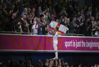 England's Max Whitlock passes the Queens Baton to Denise Lewis during the opening ceremony of the Commonwealth Games at the Alexander Stadium in Birmingham, England, Thursday July 28, 2022. (Jacob King/PA via AP)