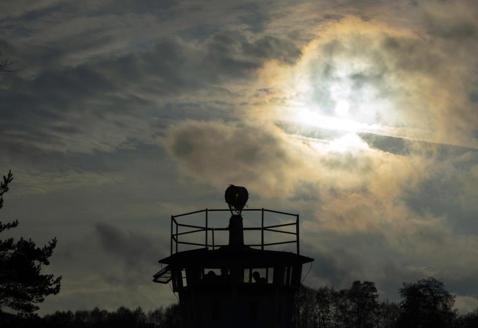 Visitors stand in a control tower of the former GDR border guard forces at the 30th anniversary of falling wall in the outdoor area of the East/West German museum in Moedlareuth, Germany, Saturday, Nov. 9, 2019. Moedlareuth, named 'Little Berlin', was the symbol of a divided village along the borderline between East and West Germany. The border ran straight through the little village. (AP Photo/Jens Meyer)