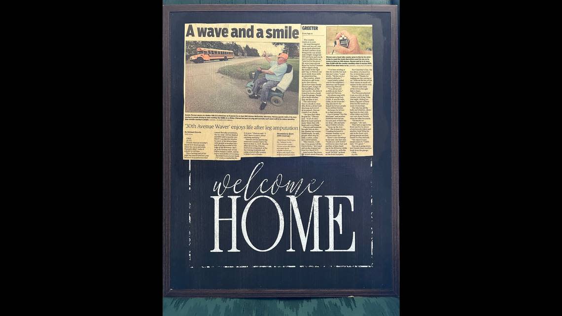 Janet Carlile gave Dennis Pierson this framed article that now hangs in his home. The article is about Pierson smiling and waving at people driving by. Carlile was the one driving the bus in the photo. The two became best friends after she worked up the nerve to stop and talk to the friendly waver. Pierson died on Tuesday.