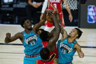 New Orleans Pelicans' Zion Williamson (1) has his shot blocked by Memphis Grizzlies' Brandon Clarke (15) and Jaren Jackson Jr. (13) during the second half of an NBA basketball game Monday, Aug. 3, 2020 in Lake Buena Vista, Fla. (AP Photo/Ashley Landis, Pool)