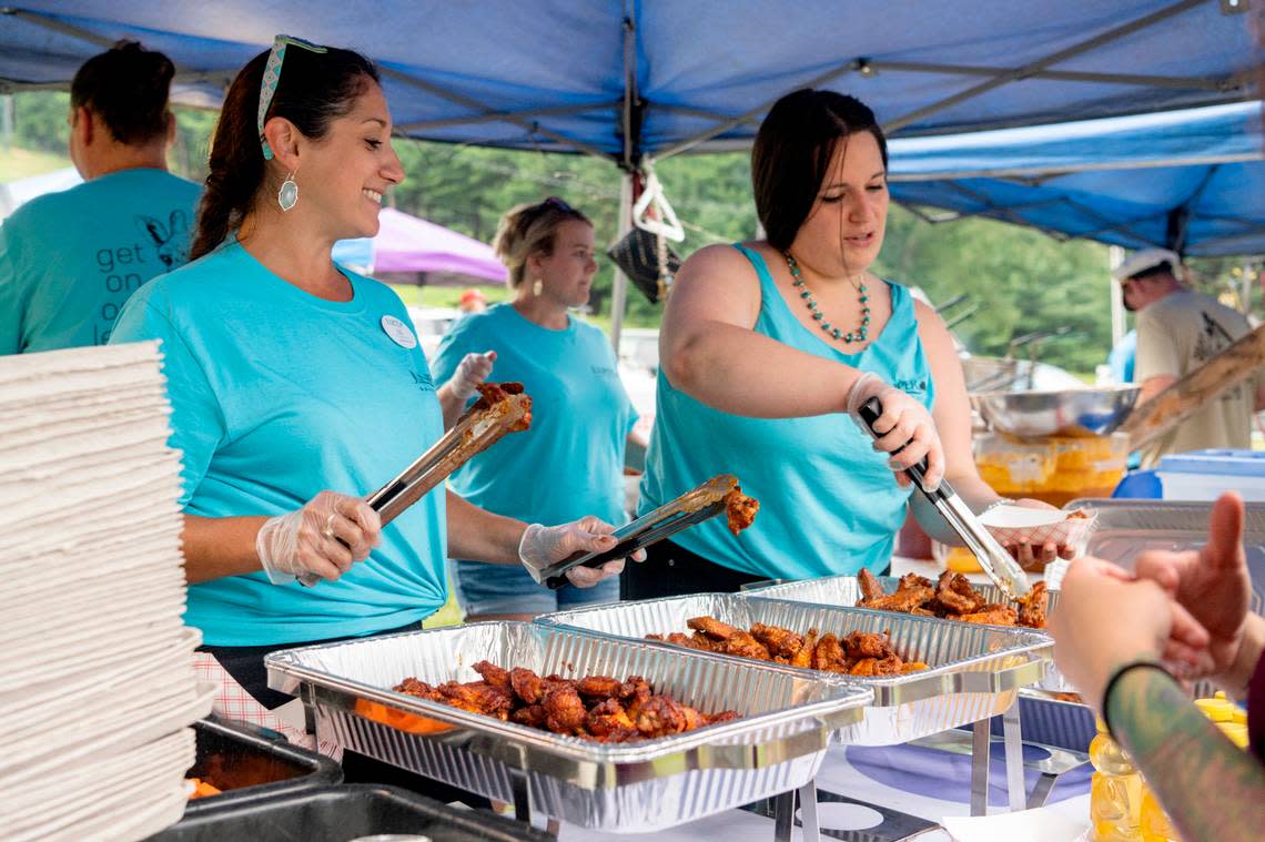 Juniper Village’s Liz Plozner-Chalfa laughs as she gets wings ready for an order during the finals for WingFest at Tussey Mountain on Thursday, Aug. 4, 2022.