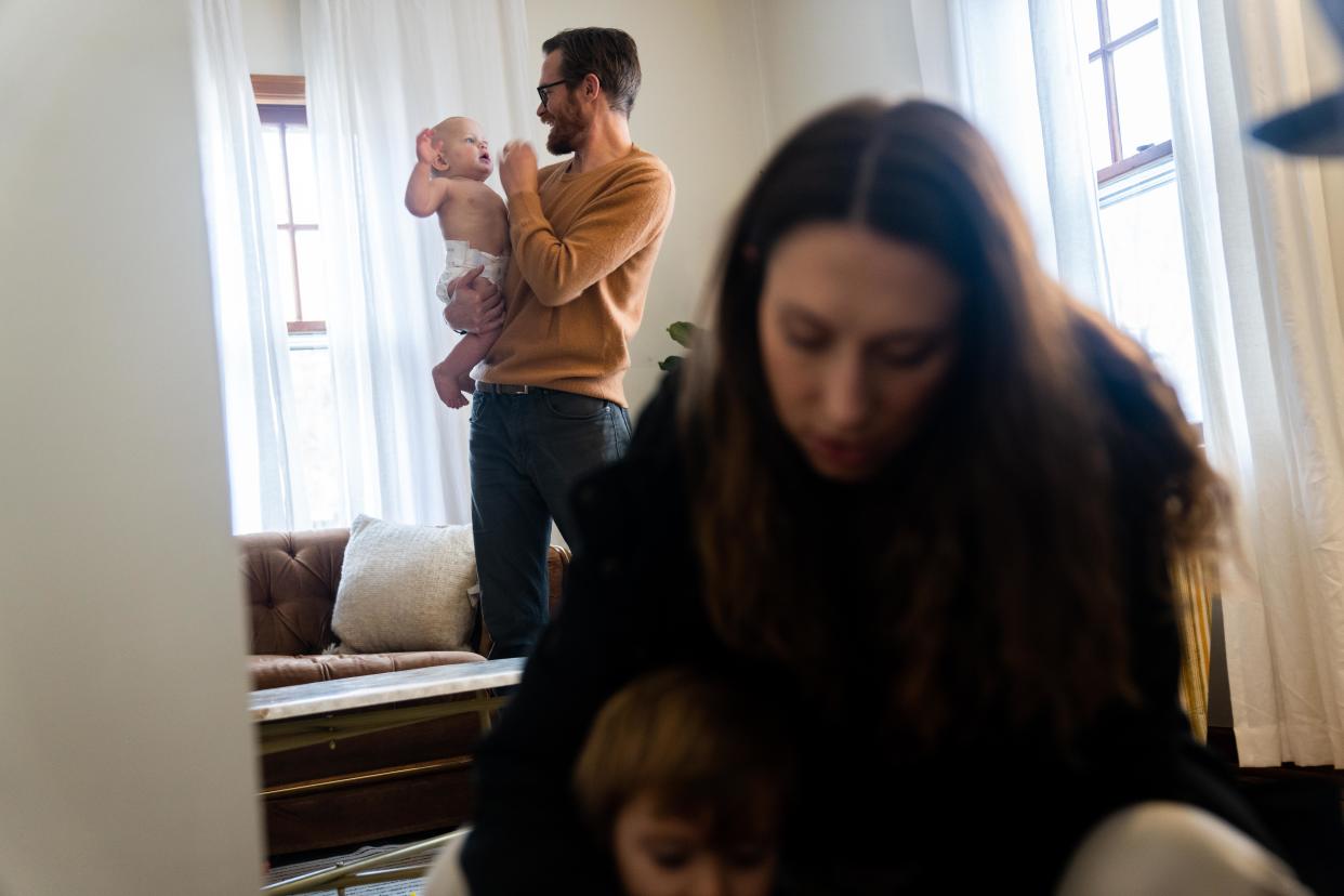 Michael Donlin holds his 9-month-old son, Paul, and Emily Donlin helps their son Walter, 2, as the family prepares for a walk Tuesday, Dec. 5, 2023, in Des Moines.