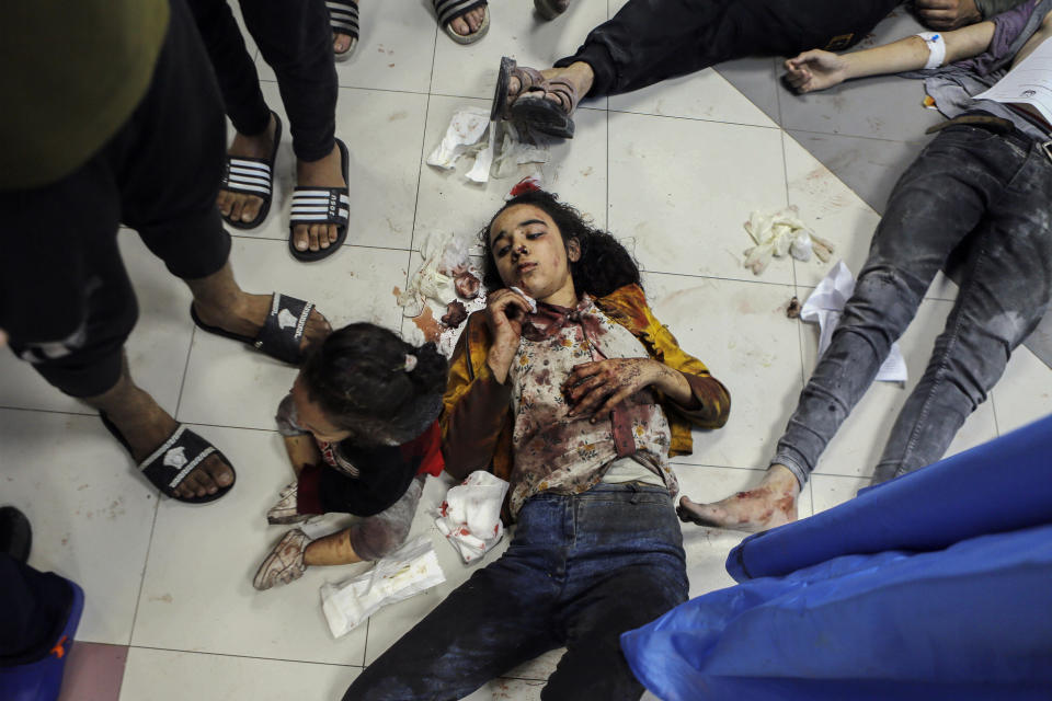 Wounded Palestinians lie on the floor in al-Shifa Hospital in Gaza City, central Gaza Strip, after arriving from al-Ahli Hospital following an explosion there, Tuesday, Oct. 17, 2023. The Hamas-run Health Ministry says an Israeli airstrike caused the explosion that killed hundreds at al-Ahli, but the Israeli military says it was a misfired Palestinian rocket. (AP Photo/Abed Khaled)