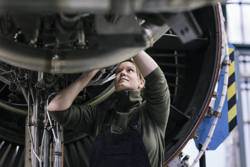 A mechanic is working on a plane