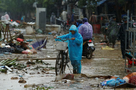 A woman walks along a street full of debris caused by flooding by Typhoon Damrey in the ancient UNESCO heritage town of Hoi An, Vietnam November 8, 2017. REUTERS/Jorge Silva