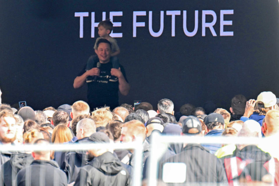 Tesla-Chef Elon Musk spricht im März in der Tesla Gigafactory Berlin-Brandenburg zu den Mitarbeitern und trägt dabei seinen Sohn X Æ A-12 auf den Schultern. - Copyright: picture alliance/dpa | Sebastian Gollnow