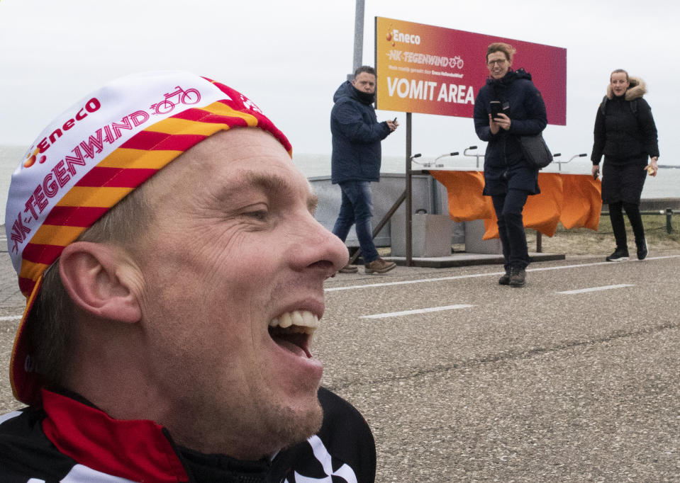 Wouter de Jonge catches his breath in the vomit area after battling gale force winds during the Dutch Headwind Cycling Championships on the storm barrier Oosterscheldekering near Neeltje Jans, south-western Netherlands, Sunday, Feb. 9, 2020. (AP Photo/Peter Dejong)