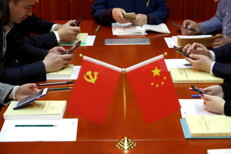 Party members, employees of at Tidal Star Group, use mobile phones during a weekly group study in an app Xuexi Qiangguo, which literally translates as 'Study to make China strong', at their party activity room in Beijing, China, February 25, 2019. Picture taken February 25, 2019. REUTERS/Jason Lee