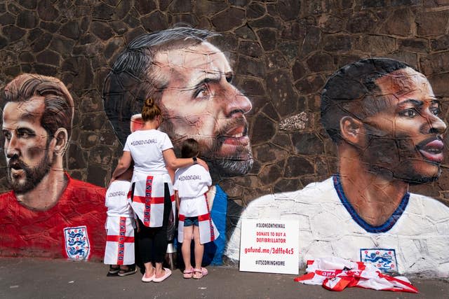 Fans by a new mural in Nuneaton by artist Nathan Parker, depicting Gareth Southgate, Harry Kane and Raheem Sterling