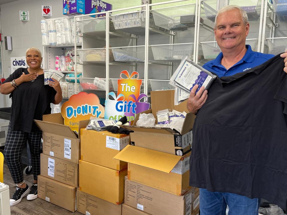 Executive Director Mark Landschoot (right) and Support Coordinator Courtney White display donated socks and other items at the Family Promise of Jacksonville Family Resource Center.