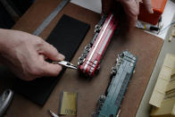 Guy Warein, a 70-year-old retiree, works on model trains in his home in Richebourg, northern France, Wednesday, Jan. 27, 2021. The old-school pastimes of making scale models and playing with miniature trains are making a comeback as a form of therapy against the pandemic blues. Sales are booming as locked-down families glue and paint models and dust off train sets. (AP Photo/Michel Spingler)