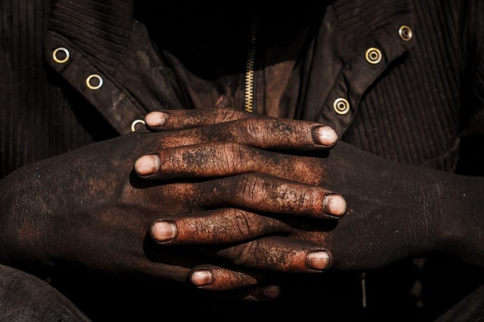 Coal-blackened hands of a worker