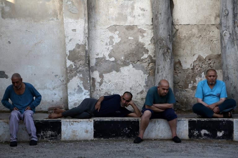 Syrian patients sit in a yard at the mental health clinic, which serves people with mental health issues caused by Syria's devastating war, on July 6, 2017