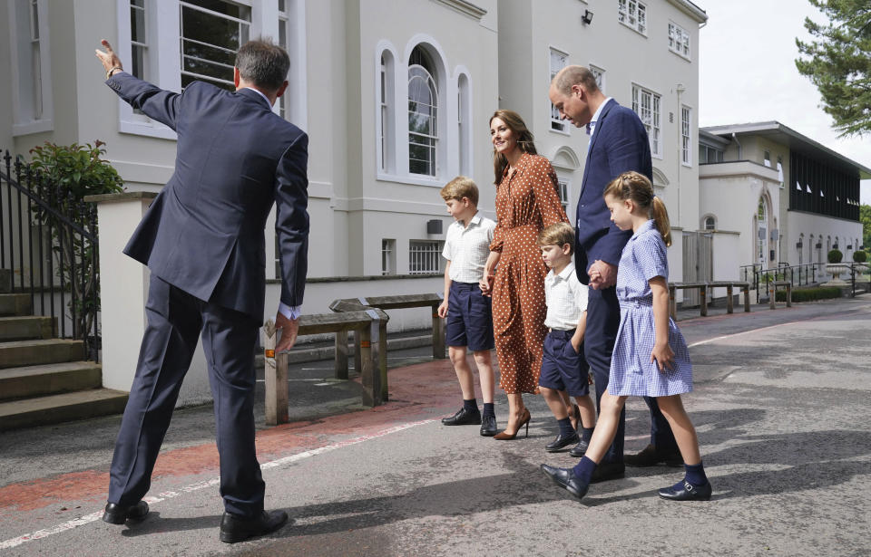 From second left, Britain's Prince George, Kate Duchess of Cambridge, Prince Louis, Prince William and Princess Charlotte are greeted by Headmaster Jonathan Perry, left, at a settling in afternoon at Lambrook School, near Ascot, England, Wednesday, Sept. 7, 2022. The settling in afternoon is an annual event held to welcome new starters and their families to Lambrook and takes place the day before the start of the new school term. (Jonathan Brady/Pool Photo via AP)