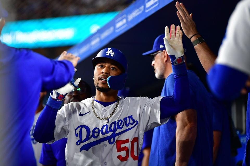 Mookie Betts is greeted in the Dodger dugout after hitting a solo home run against the Oakland A's.