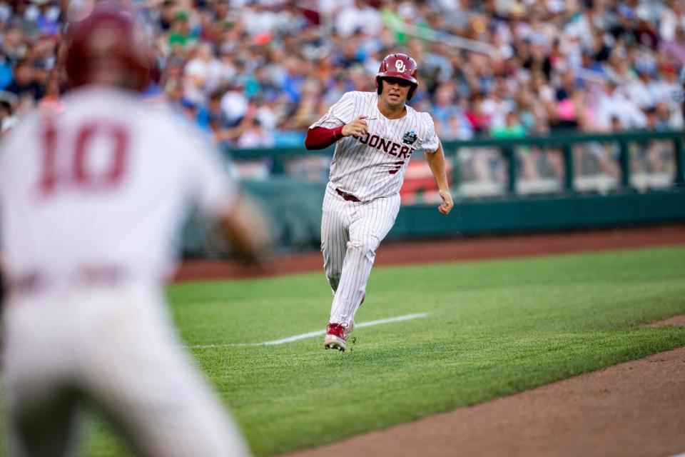 Oklahoma's Jimmy Crooks (3) scores on an error in the fifth inning against Notre Dame during an NCAA college World Series baseball game Sunday, June 19, 2022, in Omaha, Neb. (AP Photo/John Peterson)