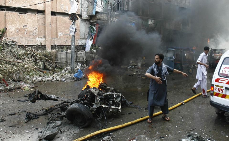 A man calls for help at the site of a bomb attack in Peshawar September 29, 2013. Twin blasts in the northwestern Pakistan city of Peshawar killed 33 people and wounded 70 on Sunday, a week after two bombings at a church in the frontier city killed scores, police and hospital authorities said. REUTERS/Khuram Parvez (PAKISTAN - Tags: POLITICS CIVIL UNREST CRIME LAW)