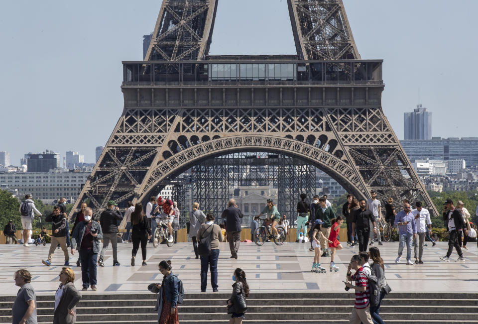 People stroll at Trocadero square next to the Eiffel Tower in Paris, Sunday, May 17, 2020 as France gradually lifts its Covid-19 lockdown. Parisians enjoying their first weekend in the sun since travel and movement restrictions were partially lifted. (AP Photo/Michel Euler)