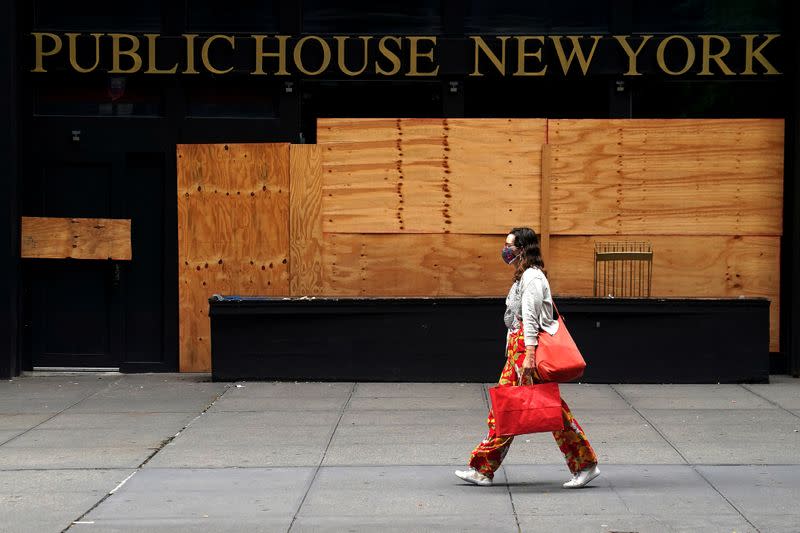 FILE PHOTO: A woman walks past a shuttered bar following the coronavirus (COVID-19) disease outbreak