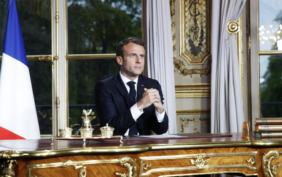 French President Emmanuel Macron sits at his desk after addressing the French nation following a massive fire at Notre Dame Cathedral, at Elysee Palace in Paris, Tuesday, April 16 2019. Macron said he wants to see the fire-ravaged Notre Dame cathedral to be rebuilt within five years. (Yoan Valat, Pool via AP)