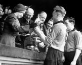 <p>Princess Elizabeth presents the Football Association Cup to Billy Wright, captain of Wolverhampton Wanderers (PA Archive) </p>