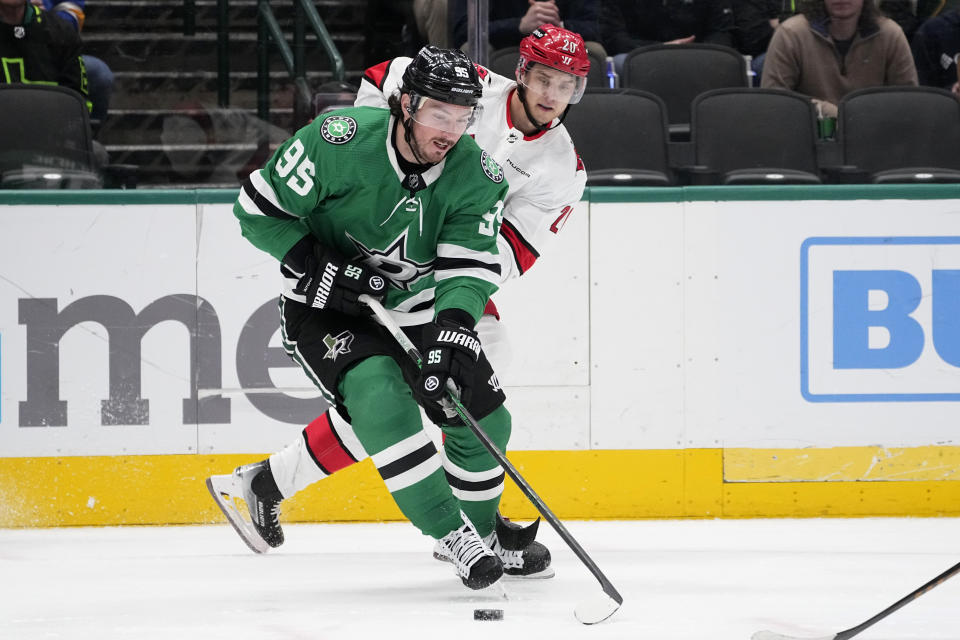 Dallas Stars center Matt Duchene (95) attempts to feed the puck to the front of the net as Carolina Hurricanes' Sebastian Aho (20) defends in the first period of an NHL hockey game in Dallas, Tuesday, Feb. 13, 2024. (AP Photo/Tony Gutierrez)