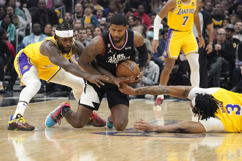 Los Angeles Clippers guard Paul George, center, goes after s loose ball along with Los Angeles Lakers guard Patrick Beverley, left, and forward Anthony Davis during the first half of an NBA basketball game Wednesday, Nov. 9, 2022, in Los Angeles. (AP Photo/Mark J. Terrill)