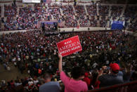 A woman holds a sign as U.S. President Donald Trump leads a rally marking his first 100 days in office in Harrisburg, Pennsylvania, U.S. April 29, 2017. REUTERS/Carlos Barria/Files