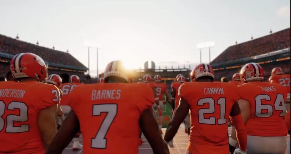 Virtual Clemson football players, including safety Khalil Barnes (7) and offensive lineman Walker Parks (64), gather at the top of The Hill atop Memorial Stadium’s east end zone in an EA Sports College Football 25 screenshot.