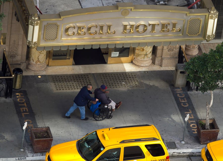 Two men pass by the front of the Cecil Hotel in Los Angeles Thursday, Feb. 21, 2013. Canadian tourist Elisa Lam had been missing for about two weeks when officials at the Cecil Hotel found her body in a water cistern on the hotel roof. Guest complaints about low water pressure prompted a maintenance worker to make the gruesome discovery Tuesday, and officials were trying to determine if the 21-year-old was killed or if her death was a bizarre accident. (AP Photo/Damian Dovarganes)