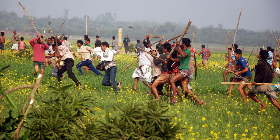 In this Sunday, Jan. 5, 2014 photo, Bangladeshi opposition party activists with sticks chase ruling Awami League party activists during a clash near a polling station in Rajshahi, northwest of Dhaka. Bangladesh. Bangladesh's ruling Awami League party on Monday, Jan. 6, 2014 won one of the most violent elections in the country's history, marred by street fighting, low turnout and a boycott by the opposition that made the results a foregone conclusion. (AP Photo)