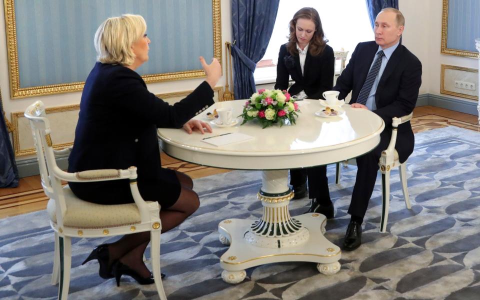 French far-right presidential candidate Marine Le Pen, left, gestures while speaking to Russian President Vladimir Putin, right, during their meeting in the Kremlin in Moscow - Credit: POOL SPUTNIK KREMLIN