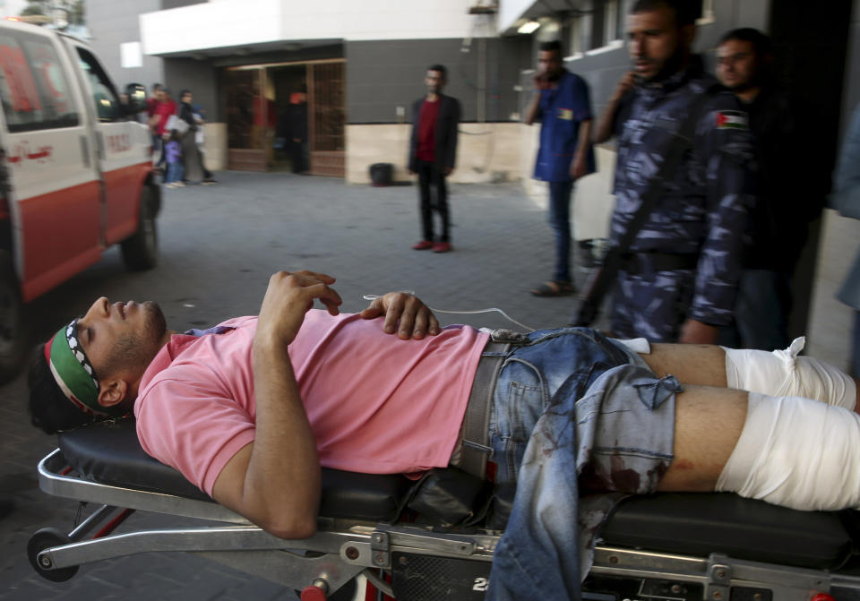 Medics move a wounded youth, who was shot by Israeli troops during a protest at the Gaza Strip's border with Israel, into the treatment room of Shifa hospital in Gaza City, Friday, May 3, 2019. Three Palestinians, including two militants, were killed by Israeli fire Friday after gunshots from the Gaza Strip wounded two Israeli soldiers, officials said, in a new flare-up that shattered a month-long easing of hostilities that was mediated by Egypt. (AP Photo/Adel Hana)