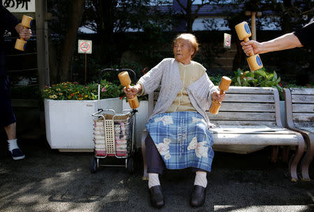Natsu Naruse, 100 year-old, exercises with wooden dumbbells during a health promotion event to mark Japan's "Respect for the Aged Day" at a temple in Tokyo's Sugamo district, an area popular among the Japanese elderly, Japan, September 18, 2017. REUTERS/Toru Hanai