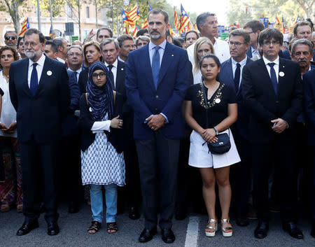 Spain's King Felipe (C), Prime Minister Mariano Rajoy (L) and Catalan regional president Carles Puigdemont (R) take part in a march of unity after the attacks last week, in Barcelona, Spain, August 26, 2017. REUTERS/Juan Medina