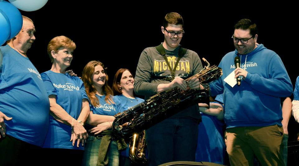 Family members of Monroe High School senior Christopher Gallaher, 17, watch as Christopher receives his new baritone saxophone from Make-A-Wish Michigan.