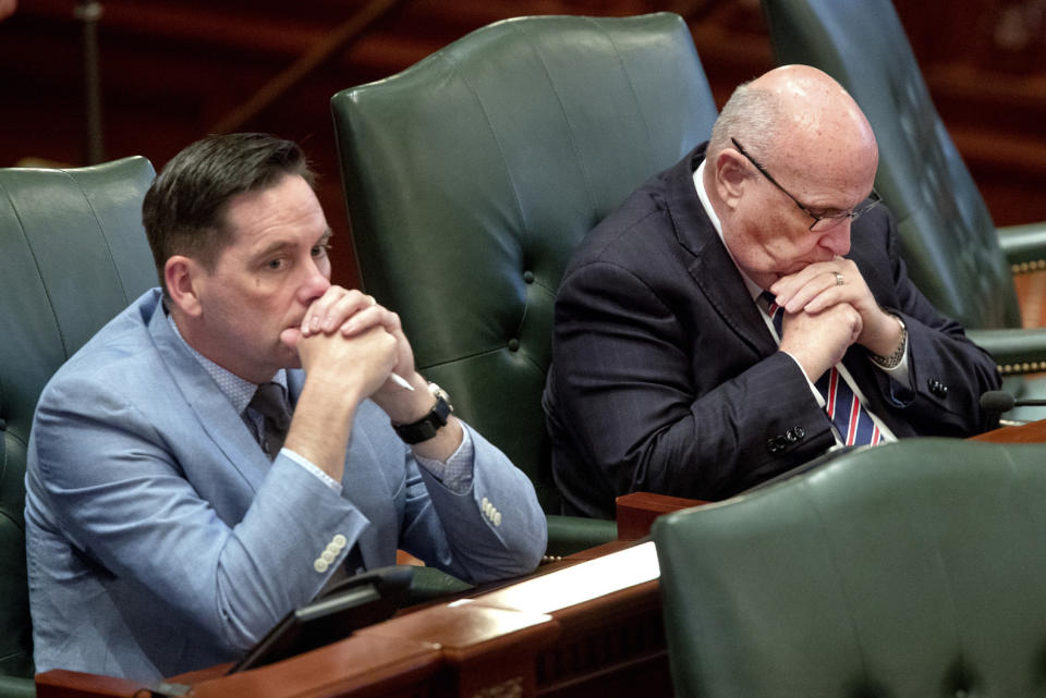 Illinois state Rep. Mike Murphy, R-Springfield, bows his head as he listens to debate on the Reproductive Health Act on the floor of the Illinois House chambers Tuesday, May 28, 2019, in Springfield, Ill. Rep. Tim Butler, R-Springfield, is on left. (Ted Schurter/The State Journal-Register via AP)