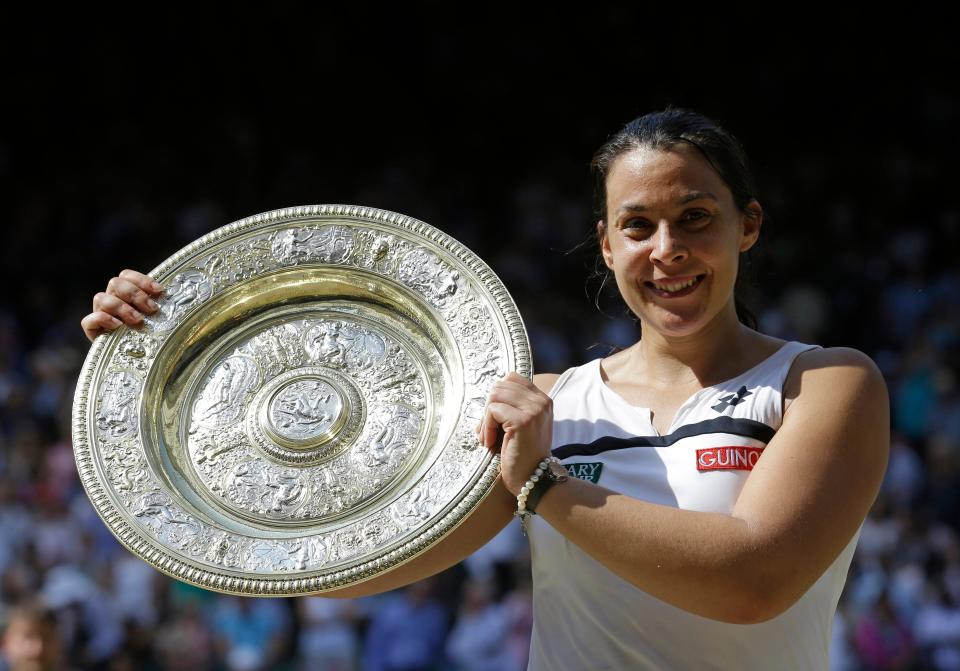 FILE - A  Saturday, July 6, 2013 file photo showing Marion Bartoli of France smiling as she holds the trophy after winning the Women's singles final match against Sabine Lisicki of Germany at the All England Lawn Tennis Championships in Wimbledon, London. Three years after winning the title at Wimbledon, Marion Bartoli said she has contracted an unknown virus and her life is an "absolute nightmare." The 31-year-old Frenchwoman is now extremely thin and said it's because she is ill. (AP Photo/Anja Niedringhaus, File)
