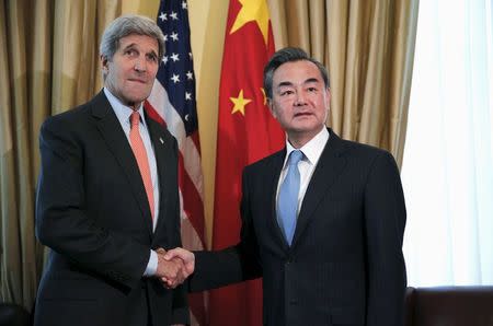 U.S. Secretary of State John Kerry (L) shakes hands with Chinese Foreign Minister Wang Yi at a hotel where the Iran nuclear talks meetings are being held in Vienna, Austria July 2, 2015. REUTERS/Carlos Barria