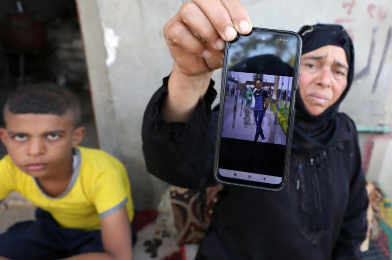 A relative of an Egyptian man who died in the storm that hit Libya shows his picture at Kafr Sharif village in Beni Suef, about 120 km south of Cairo on Wednesday. Photo by Derna Khaled Elfiq/EPA-EFE