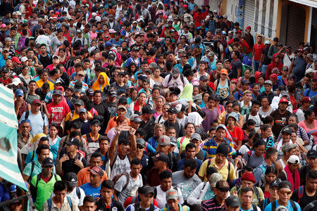 Central Americans, part of a caravan trying to reach the U.S., stand by the border gate in hope to cross into Mexico and carry on their journey, in Tecun Uman, Guatemala, October 28, 2018. REUTERS/Carlos Garcia Rawlins