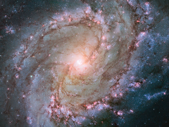 This space wallpaper is a Hubble image showing the scatterings of bright stars and thick dust that make up spiral galaxy Messier 83, otherwise known as the Southern Pinwheel Galaxy.