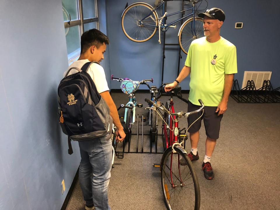 Dustin New, director of the South Bend Bike Garage, right, talks with a customer at the bike co-op in July 2022.