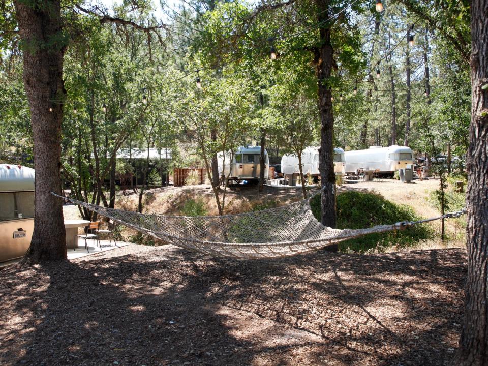 a large hammock between three trees under the shade