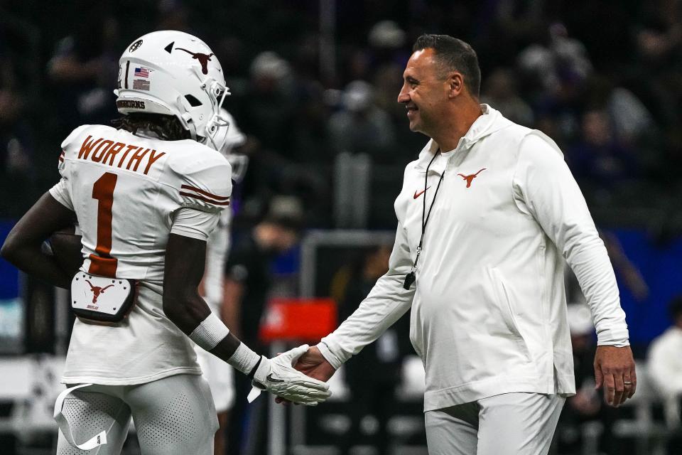 Texas Longhorns head coach Steve Sarkisian greets wide receiver Xavier Worthy (1) while warming up for the Sugar Bowl College Football Playoff semifinals game against the Washington Huskies at the Caesars Superdome on Monday, Jan. 1, 2024 in New Orleans, Louisiana.